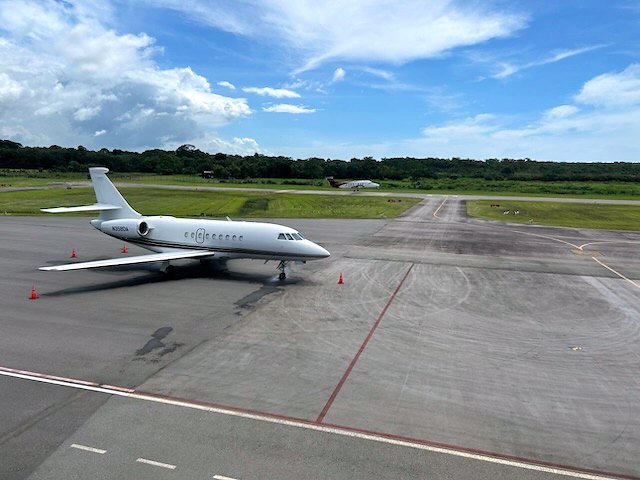 A Dassault Falcon parked on the EAG apron under a bright sky