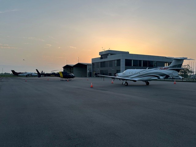 The EAG apron at sunset with a turboprop, a helicopter and the office block