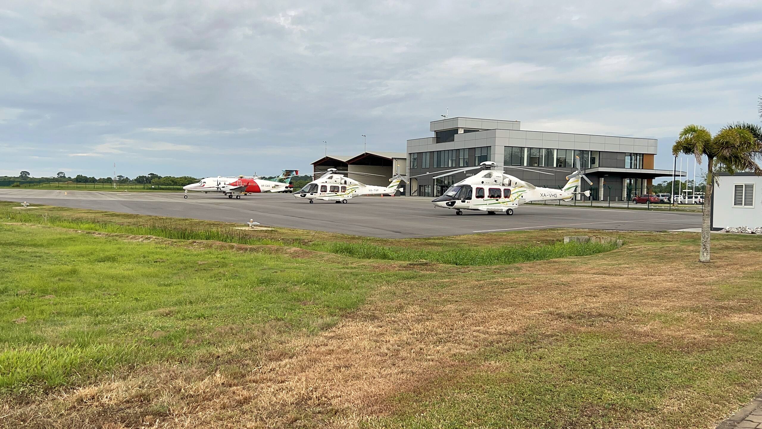 A wide view of the EAG apron with the terminal, helicopters and light aircraft