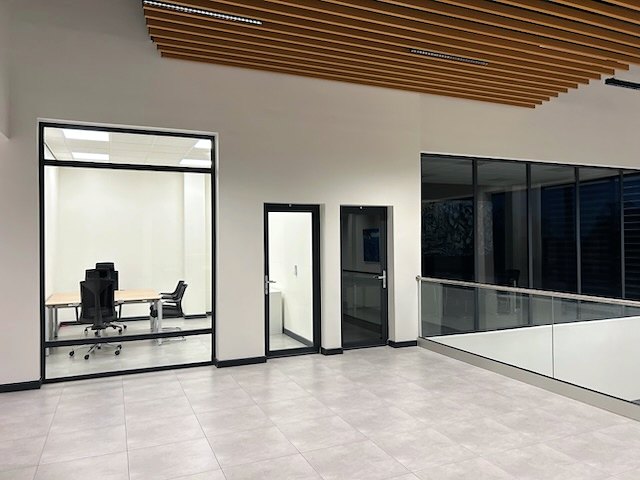 The office floor in the EAG commercial building, glazed partitions and timber-slat ceiling