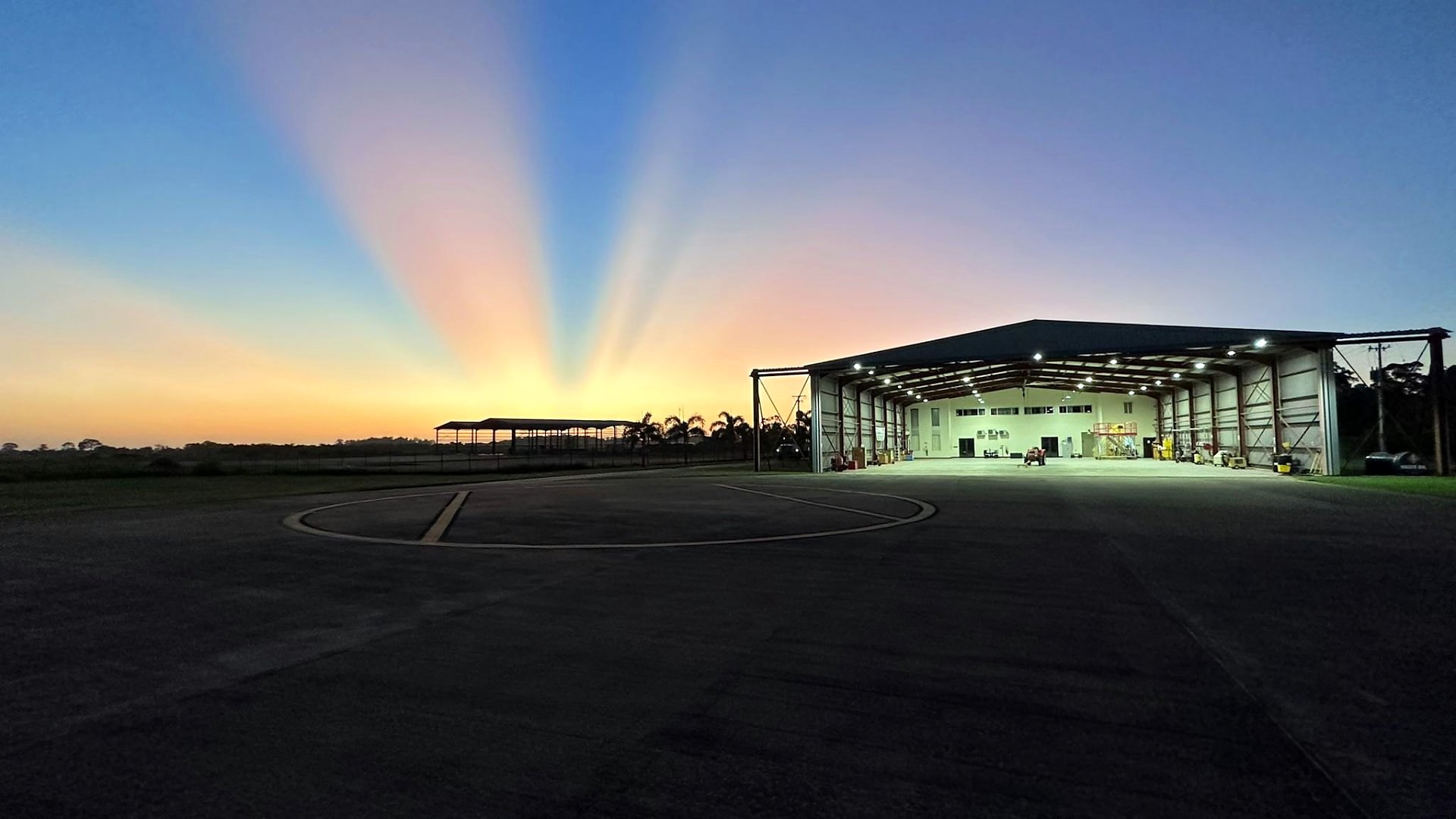 An aircraft parked in front of the EAG hangar at night