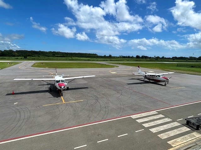 Light aircraft lined up on the EAG apron under cumulus