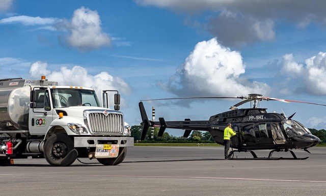 A fuel bowser and a helicopter with crew on the EAG apron