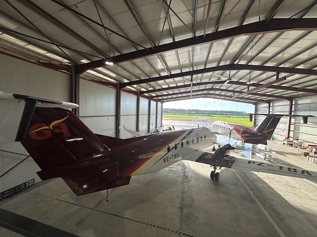 Two business jets inside an EAG hangar under the steel portal frame